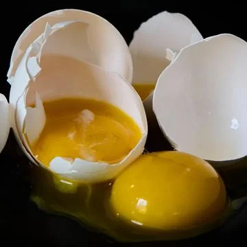 Broken Eggs on black background Stock Photos