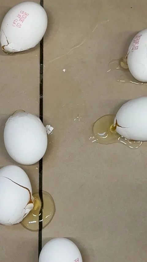 Broken eggs on brown surface with cracks and spills, concept of fragility a.. Stock Footage 341420317