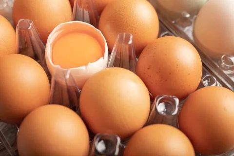 Broken eggs of duck in plastic box on the wooden table Stock Photos