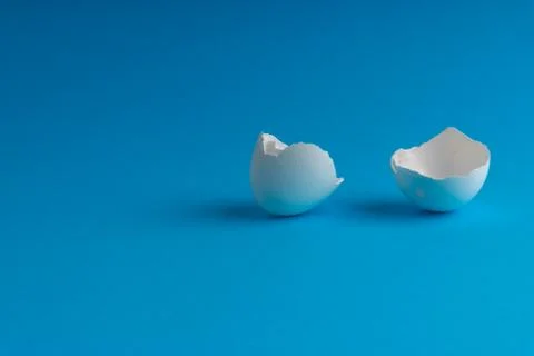 Broken eggshell on the blue background with selective focus Fotos Stock