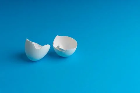 Broken eggshell on the blue background with selective focus 写真素材