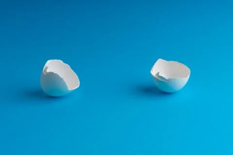 Broken eggshell on the blue background with selective focus 写真素材