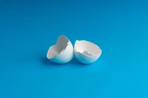 Broken eggshell on the blue background with selective focus 库存照片