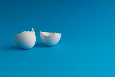 Broken eggshell on the blue background with selective focus Stock-Fotos