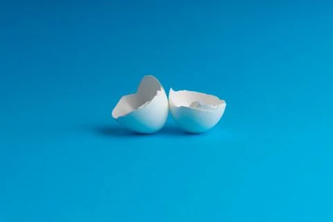 Broken eggshell on the blue background with selective focus Fotos Stock