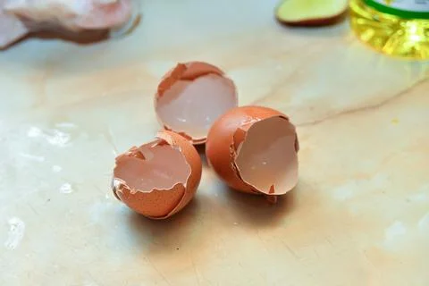 Broken eggshell of three eggs lies on the table in the kitchen at home. Stock Photos
