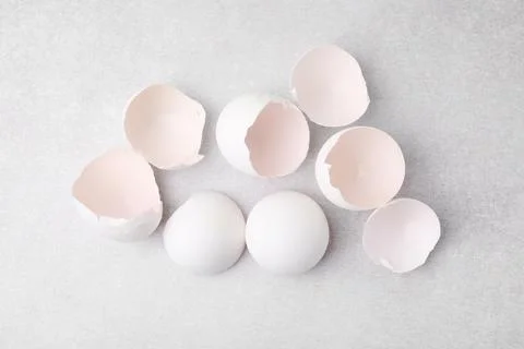 Broken eggshells on grey textured table, top view Stock Photos
