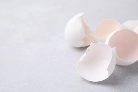 Broken eggshells on grey textured table, closeup. Space for text Stock Photos