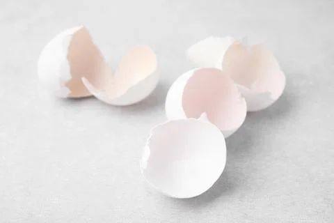 Broken eggshells on grey textured table, closeup Stock Photos