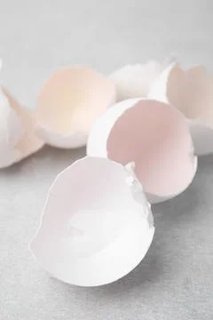 Broken eggshells on grey textured table, closeup Stock Photos