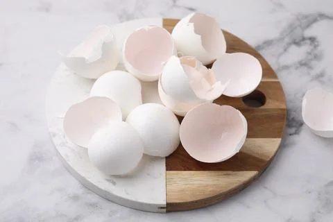 Broken eggshells on light marble table, closeup 스톡 사진