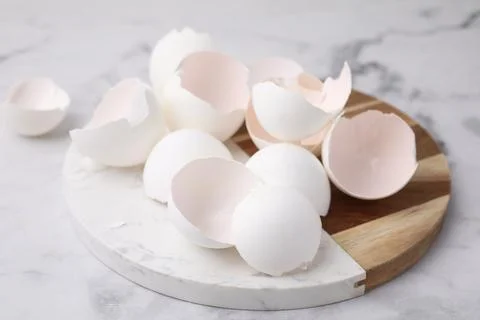 Broken eggshells on light marble table, closeup 스톡 사진