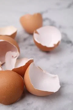 Broken eggshells on light marble table, closeup 스톡 사진