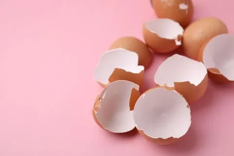 Broken eggshells on pink background, closeup. Space for text 스톡 사진
