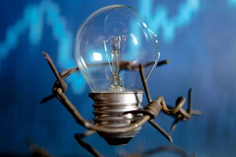 Broken electric light bulb with barbed wire. Concept of electricity prices .. Stock Photos