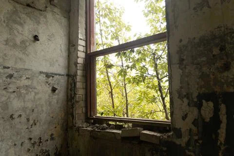 A broken, empty window of building ruins from Soviet times. Stock Photos