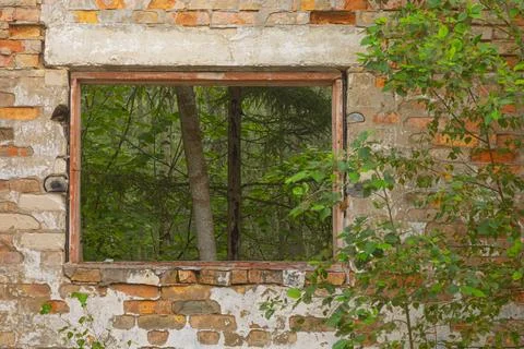 A broken, empty window of building ruins from Soviet times. Stock Photos
