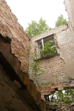 A broken, empty window of building ruins from Soviet times. Stock Photos