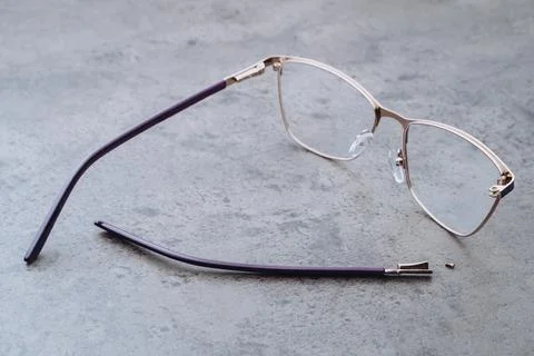Broken eyeglasses lying on table in optical workshop Stock Photos