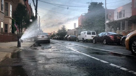 Broken fire hydrant water spraying out into street summer sunset 4K and 1080  Stock Footage 95276559