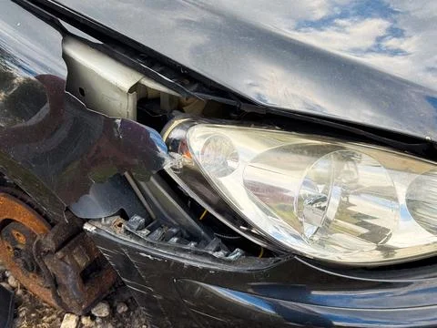 Broken front fender and headlight from a car showing cracked plastic panel,.. Stock Photos