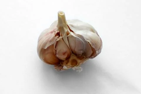 Broken garlic on a light  white background. Food photography Stock Photos