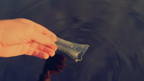 Broken glass bottle in hand from lake. Marine debris. Glass pollution in lake. Stock Footage 324924309