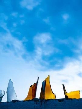 Broken Glass Bottles Embedded in Concrete Wall Against Blue Sky - Security .. Stock Photos