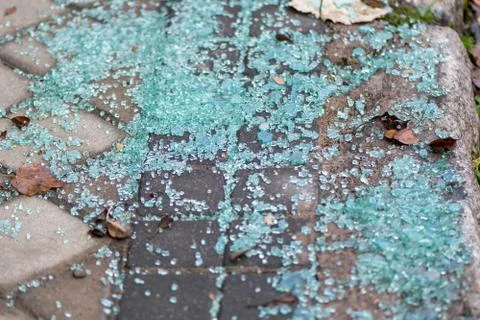 Broken glass on the sidewalk. Stock Photos