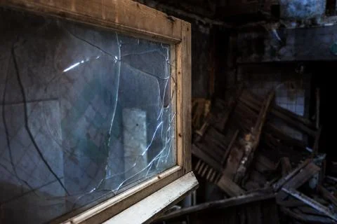 Broken glass in the windows of an old abandoned mystical house. A horror pict Stock Photos