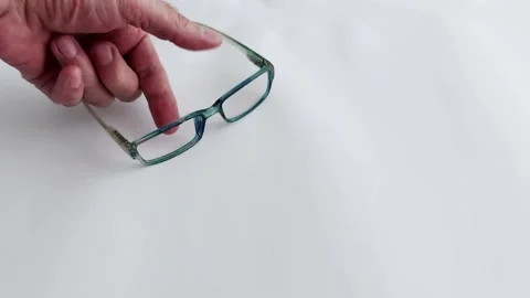 Broken Glasses Held in Hand on White Background- Close-Up Footage Stock-Footage 313117440