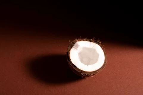 The broken half of the coconut on brown surface Stock Photos