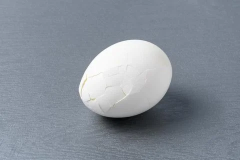 Broken hard-boiled egg with cracks on the shell surface Stock Photos