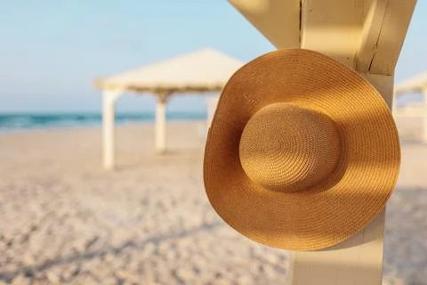 A broken hat hangs on a pole on the beach. relaxation on the beach. Stock Photos