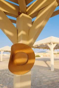 A broken hat hangs on a pole on the beach. relaxation on the beach. Stock Photos