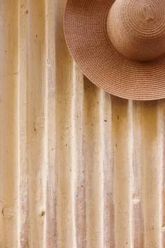 A broken hat hangs on the wall of an old house. Fashion &amp; Style. Stock Photos