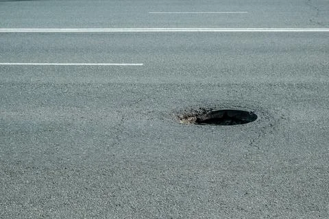 Broken hatch on the road. external sewerage hatch, danger on the road for the Stock Photos