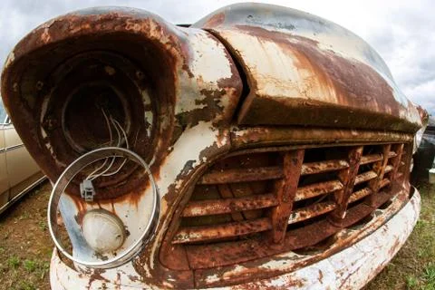 Broken Headlight Hangs From Old Rusted Junkyard Vehicle Stock Photos