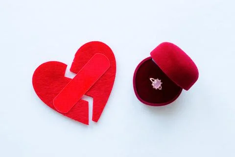 Broken heart with a patch and a wedding ring Stock Photos