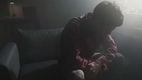 Broken hearted man sitting alone in dark room after breakup. Stock Footage 318650770