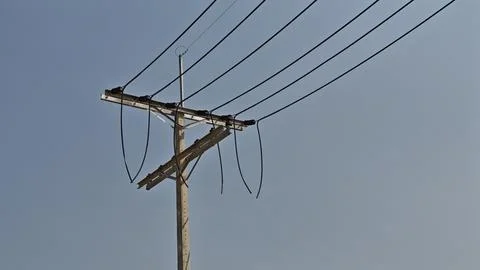 Broken high voltage electrical power line jumper wire hanging from concrete. Stock Photos