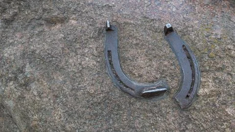 Broken horseshoe on a stone texture. Copyspace Photo Foto stock