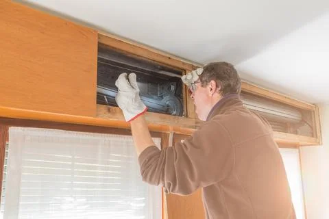 Broken house roller shutter. Man agape and surprised by the damage Stock Photos