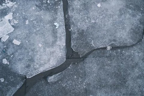 Broken ice with jagged chunks floats on dark winter water, showcasing pattern Stockfoto's