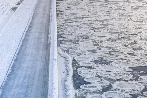 Broken ice pieces floating through the river and ice shore Stock Photos