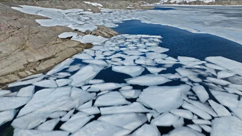 Broken ice sheets floating on alpine lake at Hardangervidda National Park. Stock Footage 328130634