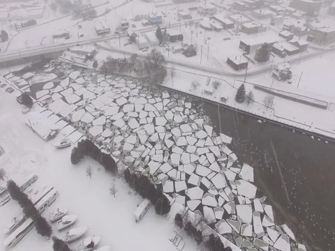 Broken Ice sheets in Small Town River - Snowing Stock Footage 71285757