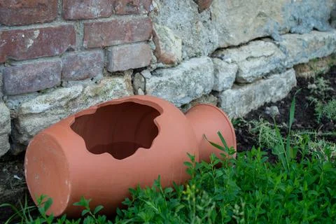 Broken jug in the yard under a brick wall Stock Photos