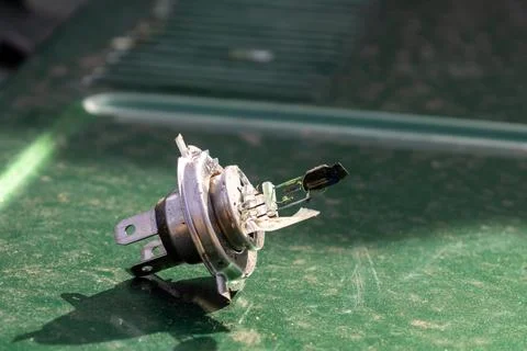 Broken Lamp Component Lying on a Green Surface Under Natural Light During D.. Stock Photos