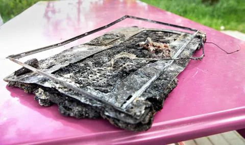 Broken laptop computer spoiled by flame melted plastic. Computer damage Stock Photos
